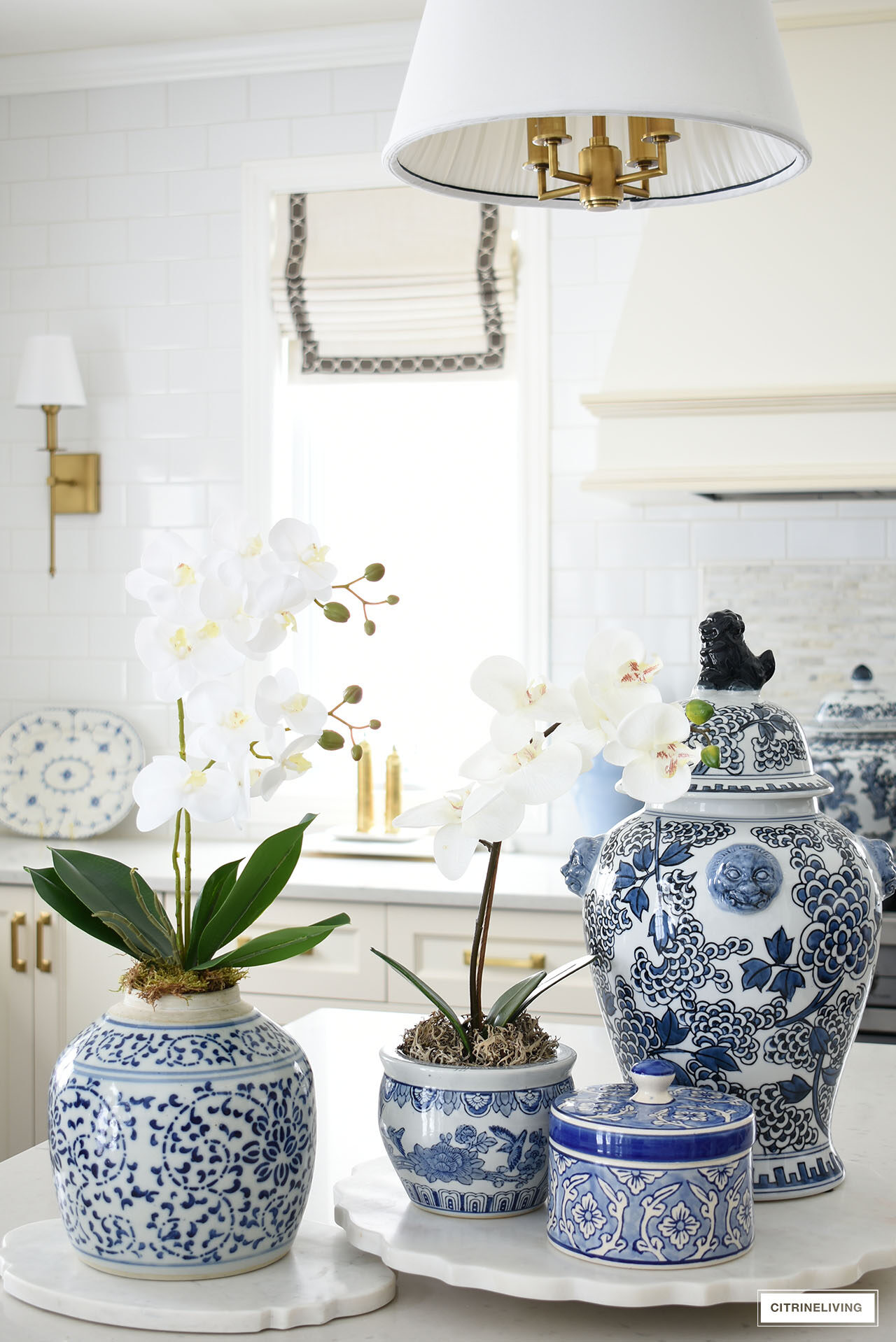 Kitchen island decorated with blue and white ginger jars and orchids.
