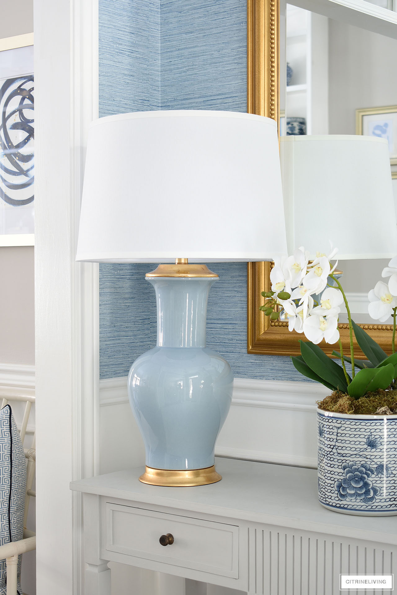 Elegant blue and gold lamp with a white linen shade