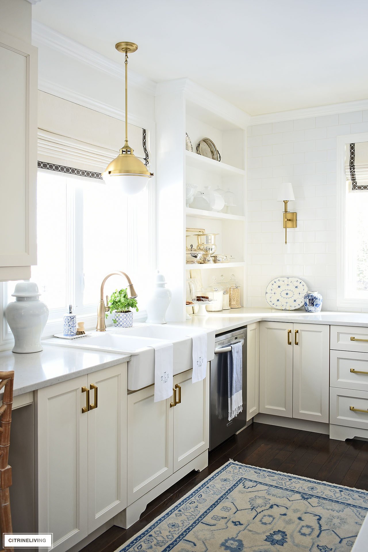 Elegant kitchen styled for spring with simple and classic decor - silver serving pieces, blue and white chinoiserie, ginger jars and monogrammed towels.