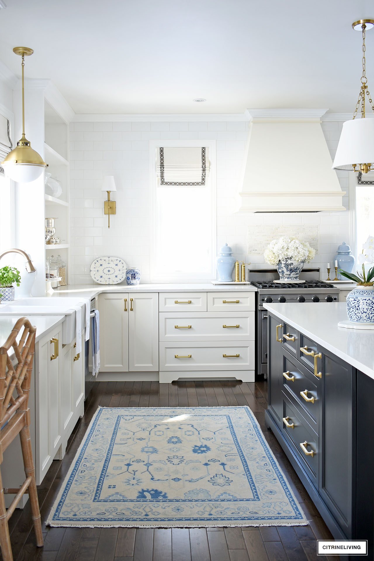 Elegant and traditional, white and black kitchen styled for spring with blue and white ginger jars, white orchids and hydrangeas.