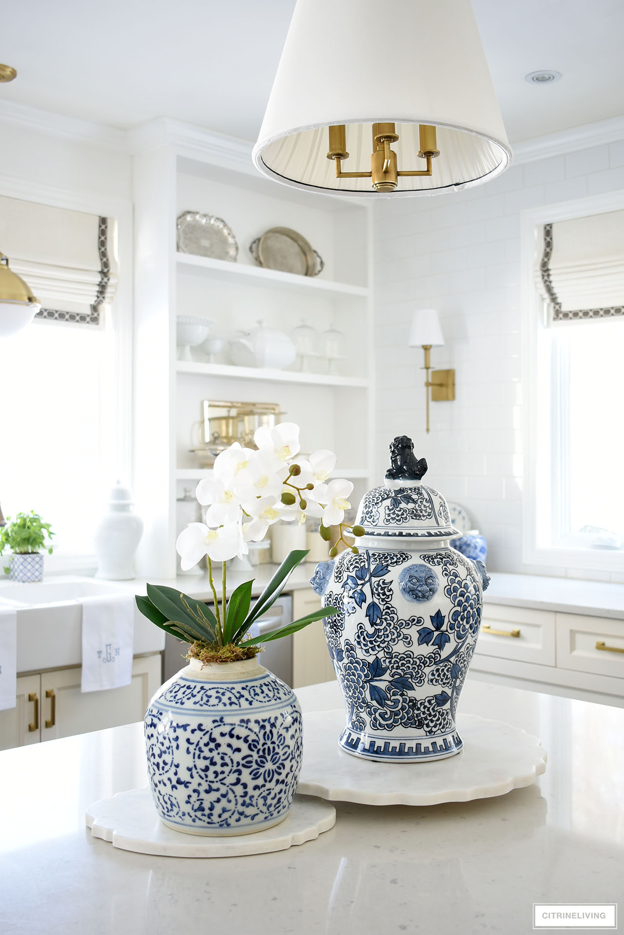 Kitchen island decorated for spring with a large blue and white ginger jar and an elegant orchid arrangement.