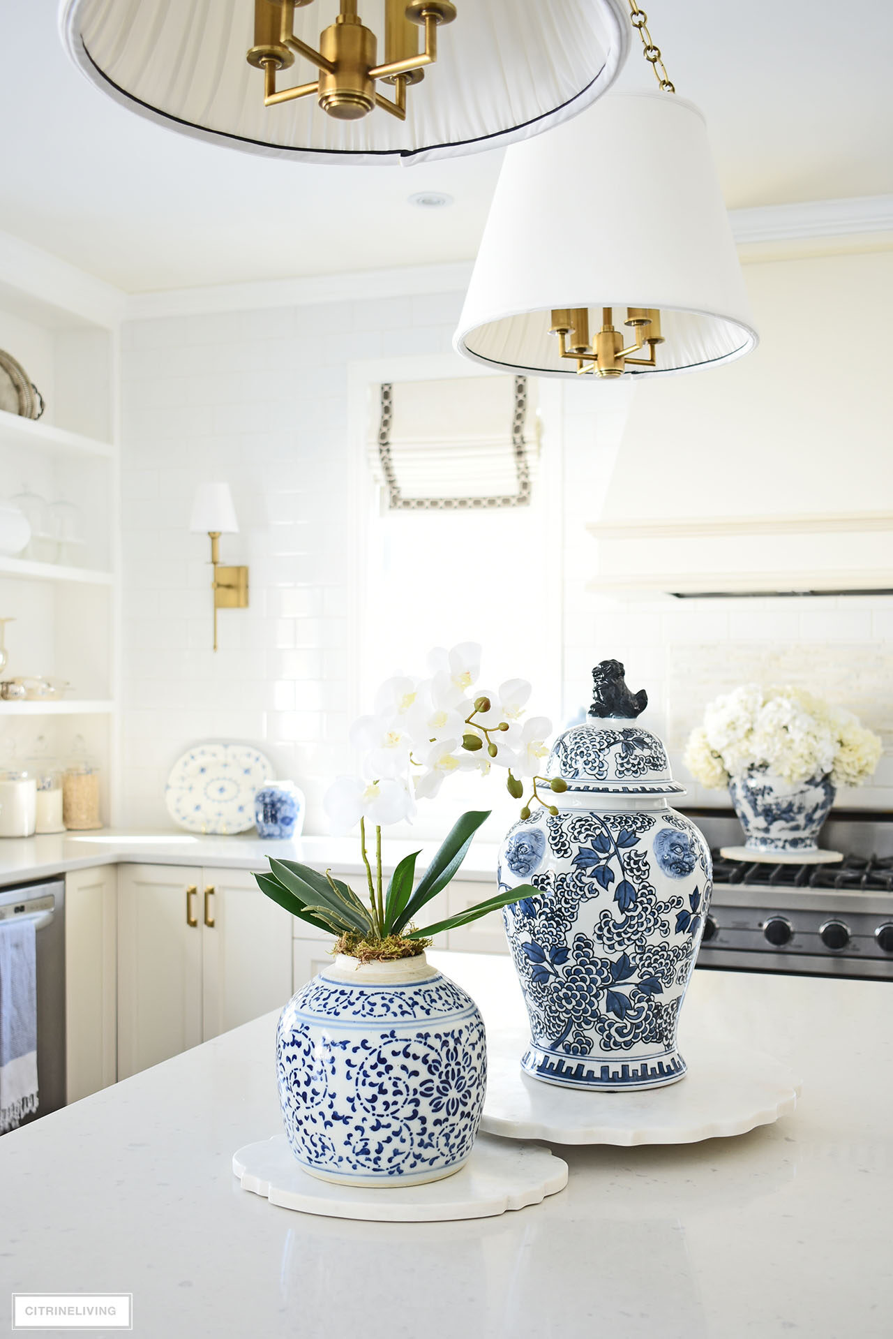Kitchen island decorated for spring with blue and white ginger jars and an elegant orchid arrangement.