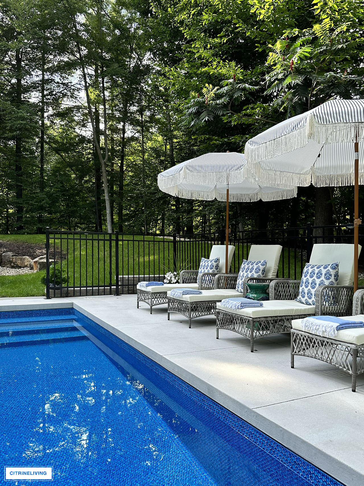 Resort style pool with loungers and fringe umbrellas.