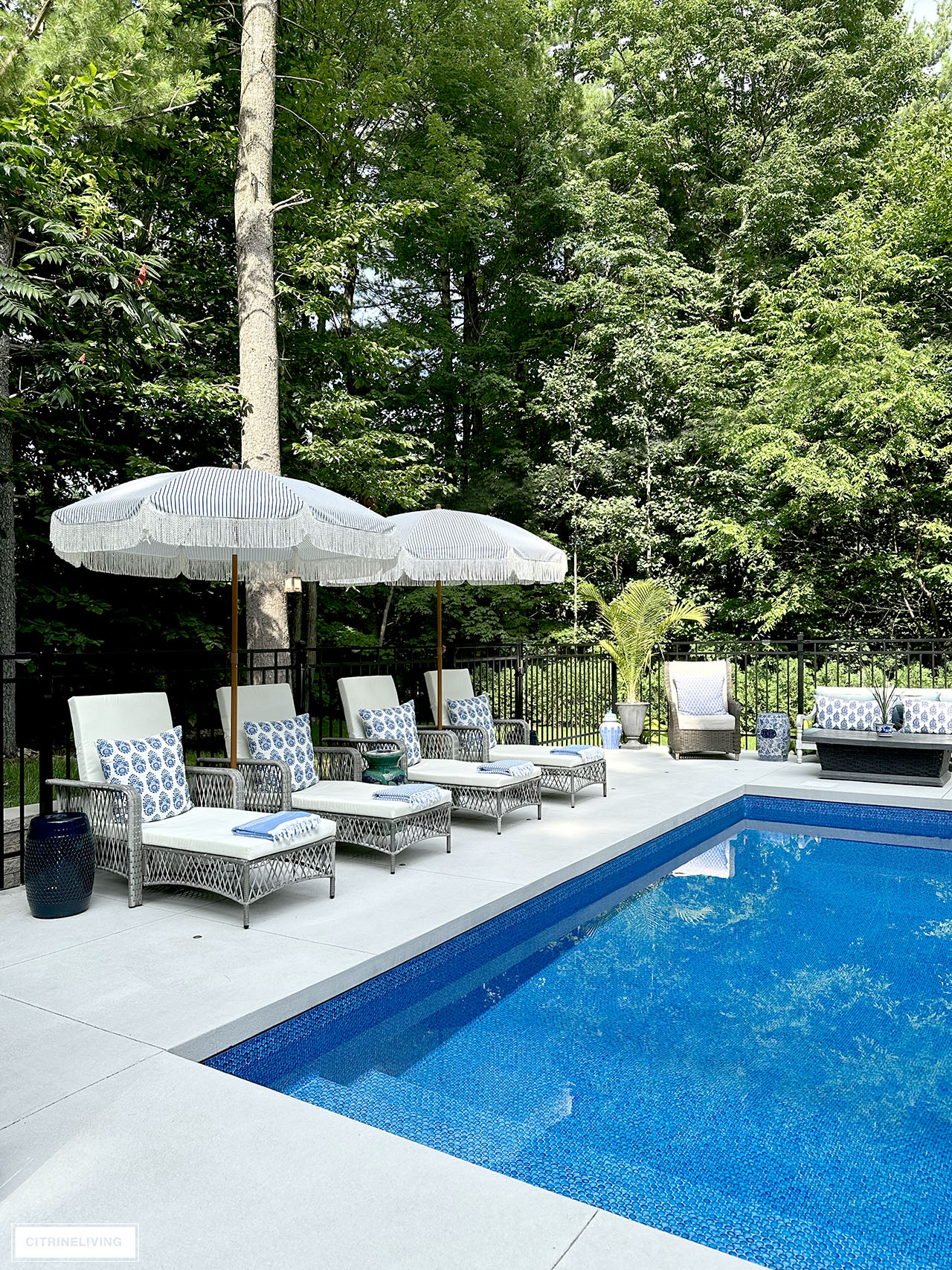 Resort style pool with loungers and fringe umbrellas