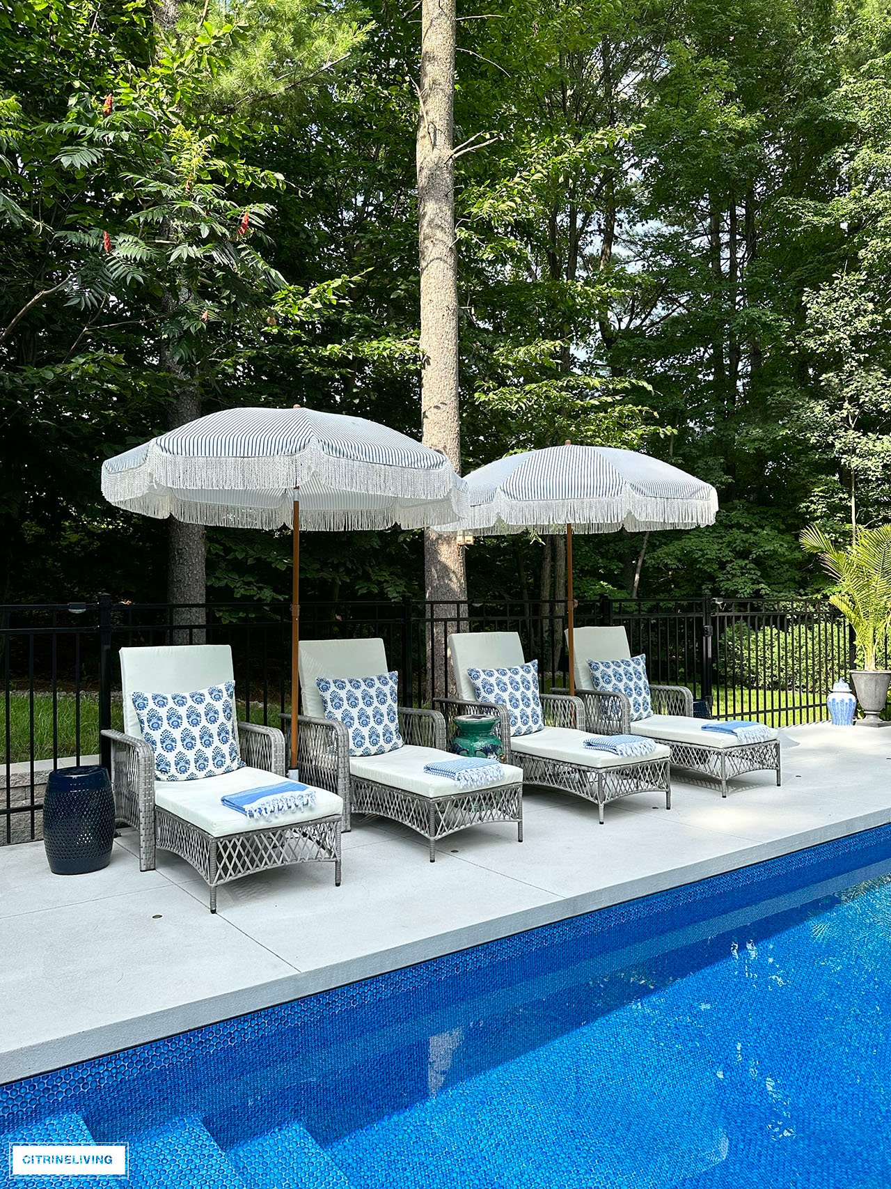 Resort style pool with loungers and fringe umbrellas.