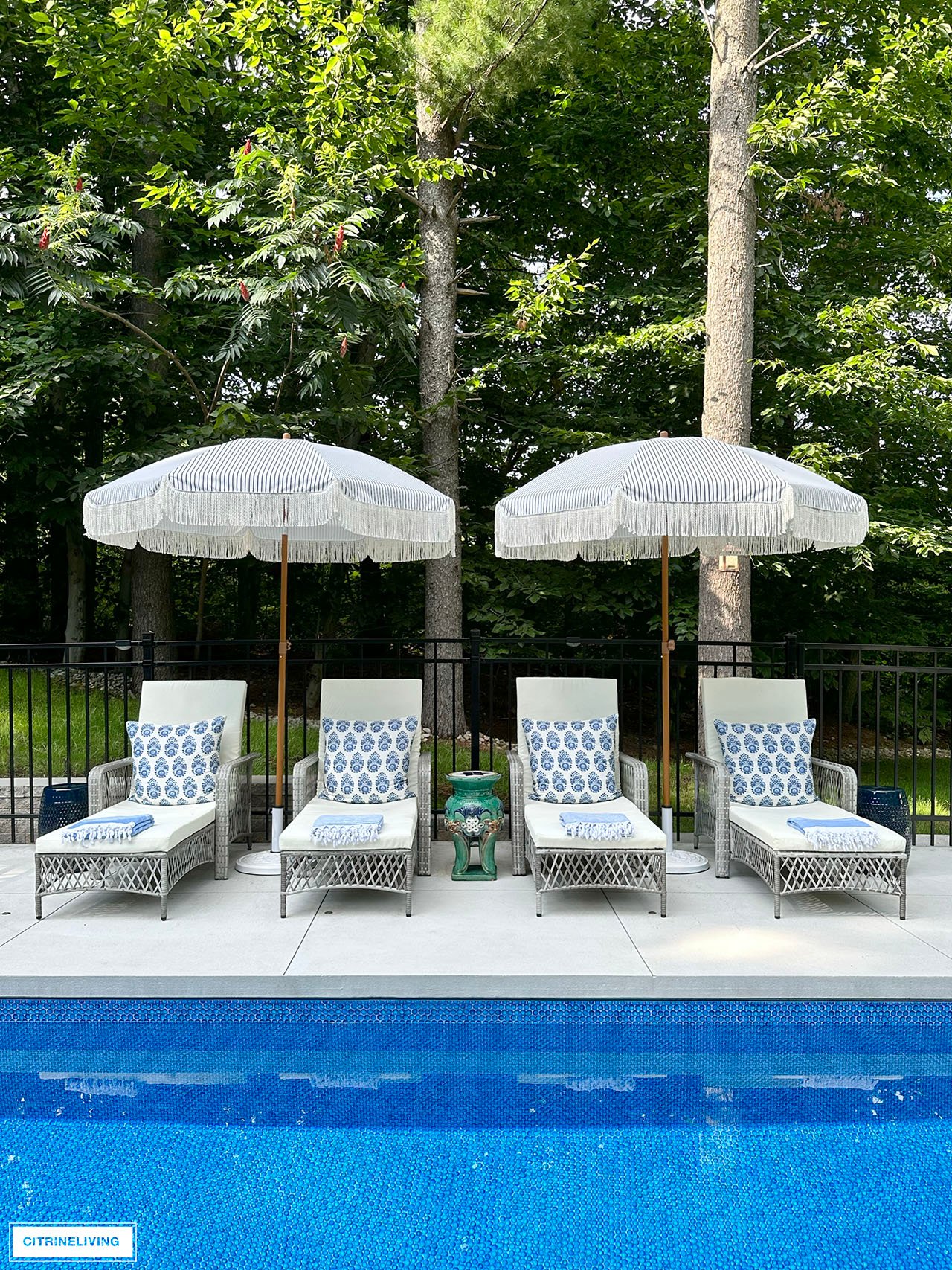 Resort style pool with loungers and fringe umbrellas.