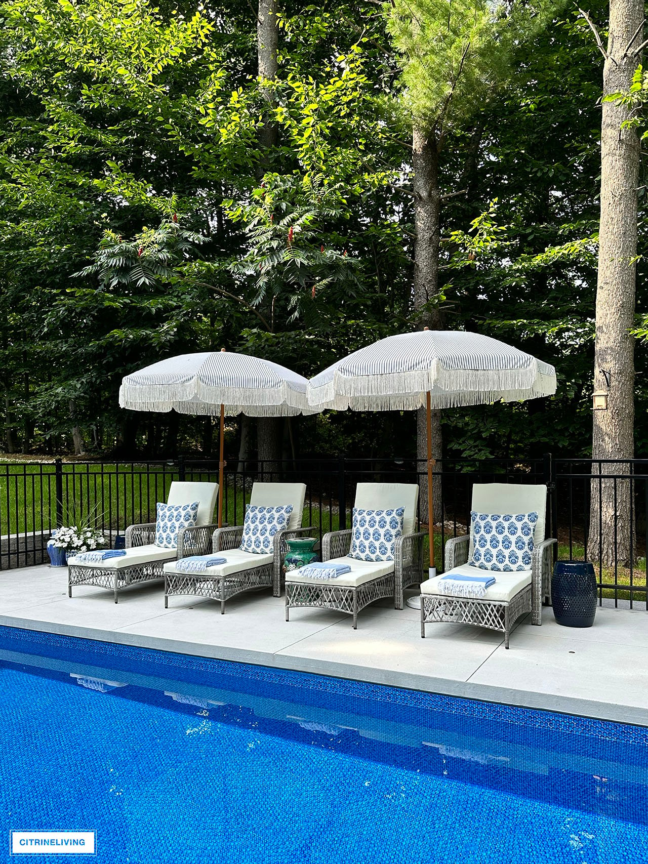 Resort style pool with loungers and fringe umbrellas.