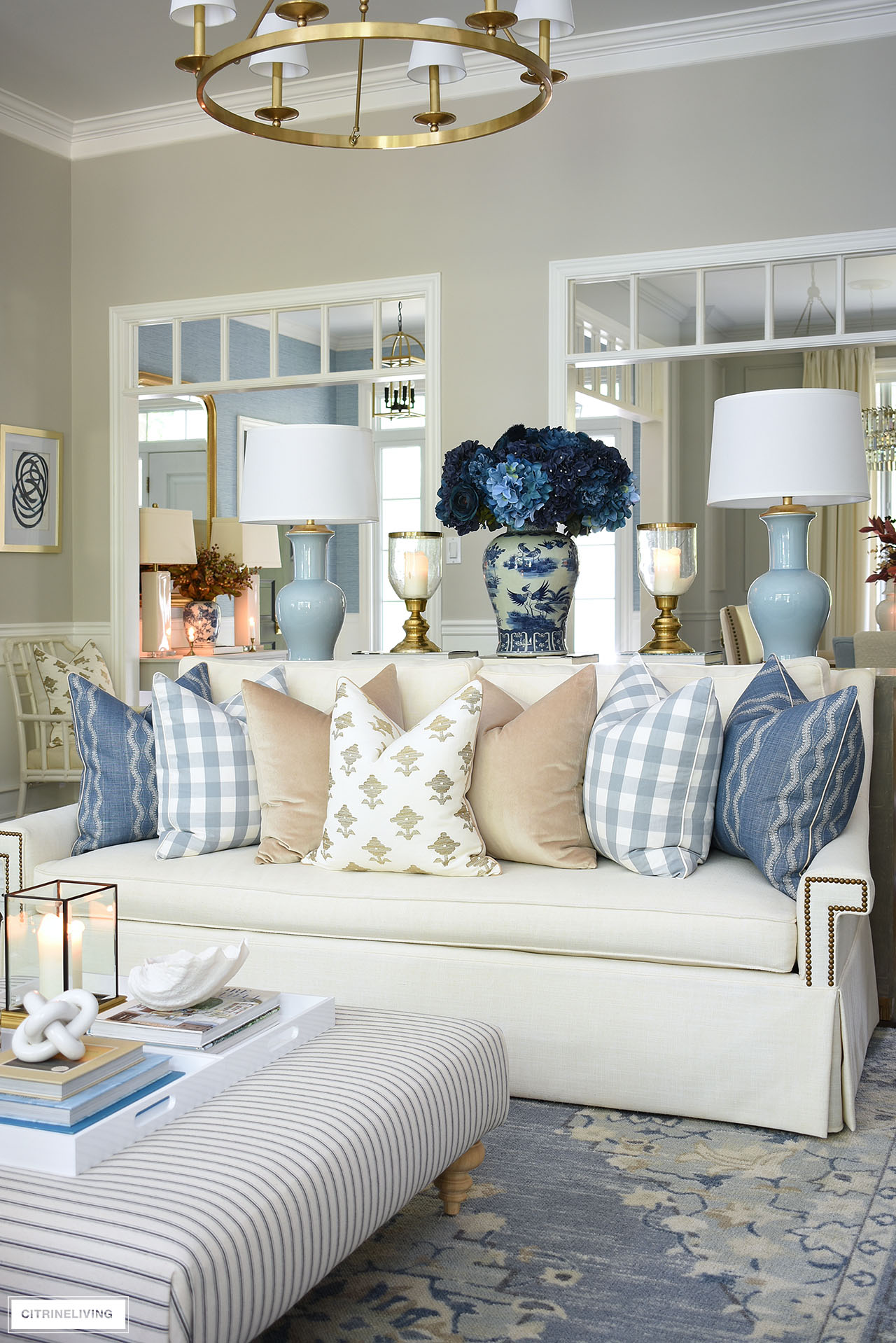 Ivory skirted sofa styled with luxe pillows in blue, tan and ivory