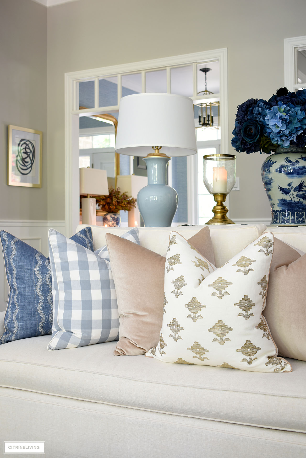 Sofa styled with luxe pillows in blue, tan and ivory