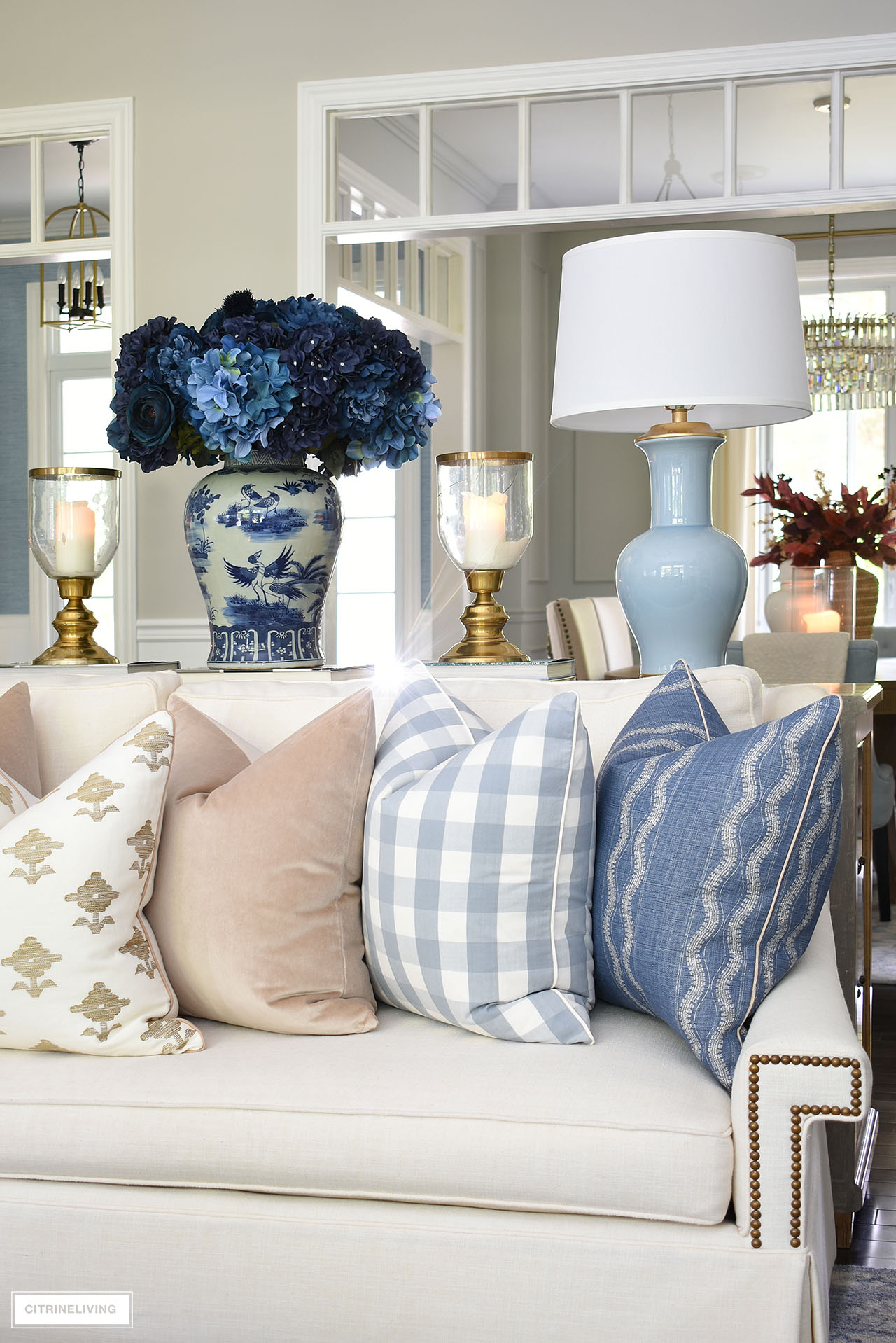 Luxe pillows in blue, tan and ivory styled on an ivory sofa