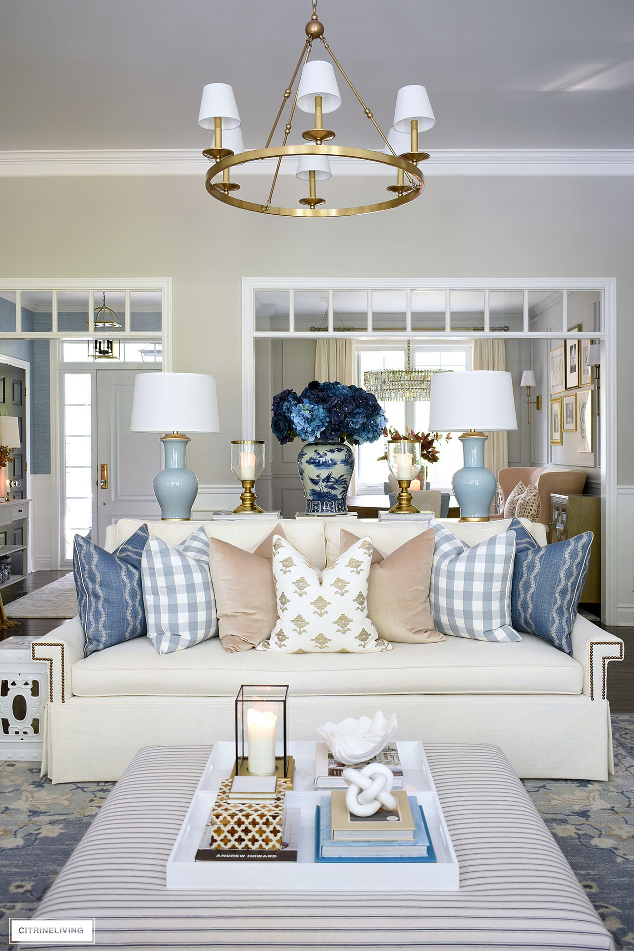 Ivory skirted sofa styled with luxe pillows in blue, tan and ivory