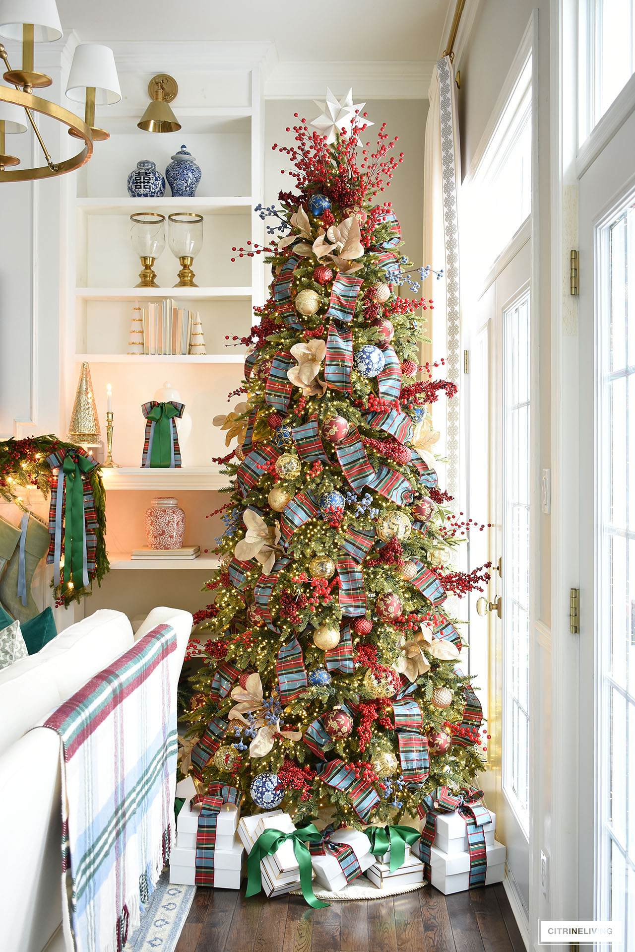 Gorgeous Christmas tree with red and blue plaid ribbon, red, blue and ld ornaments and red berry picks.