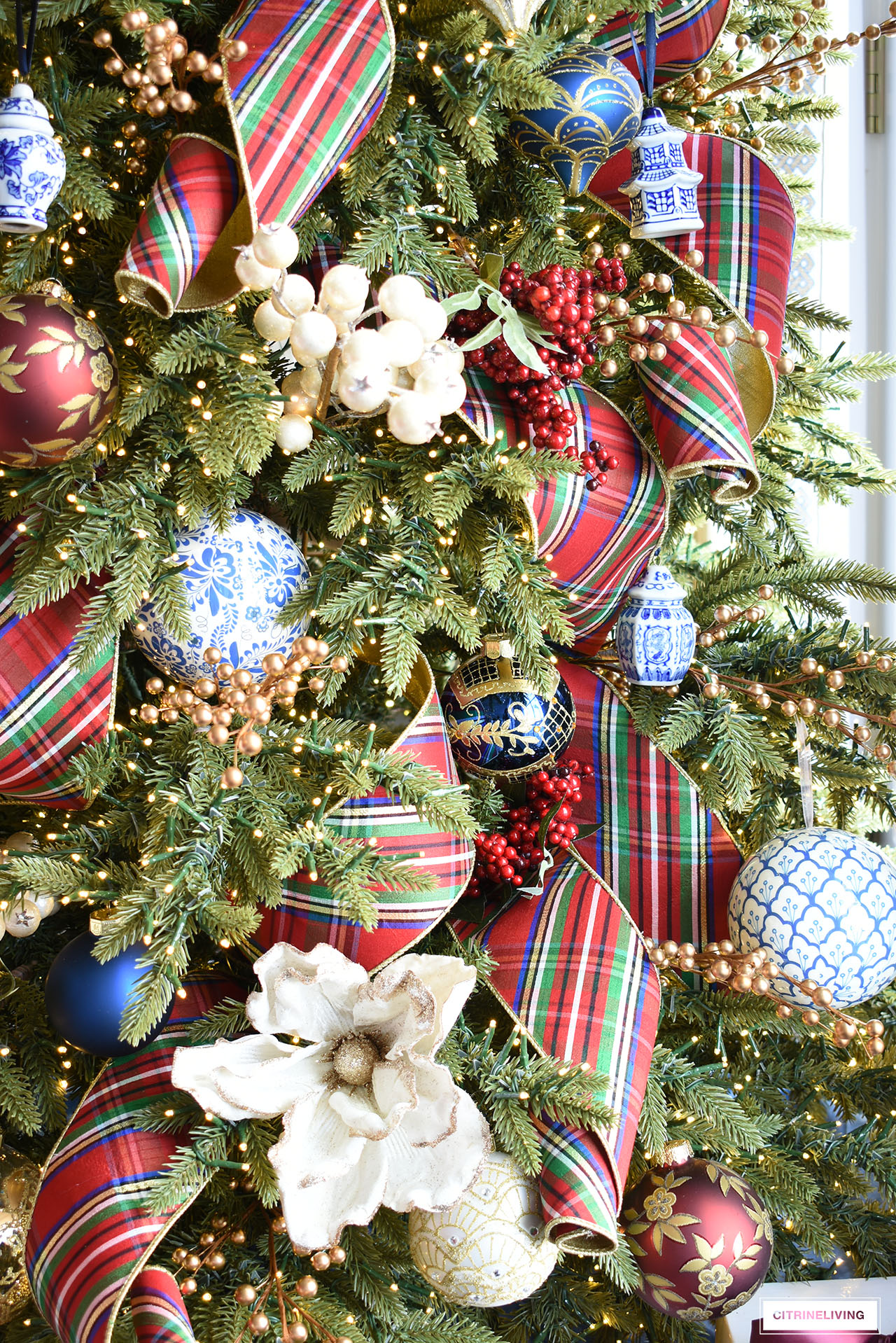 Christmas tree with blue and white ornaments, red plaid ribbon