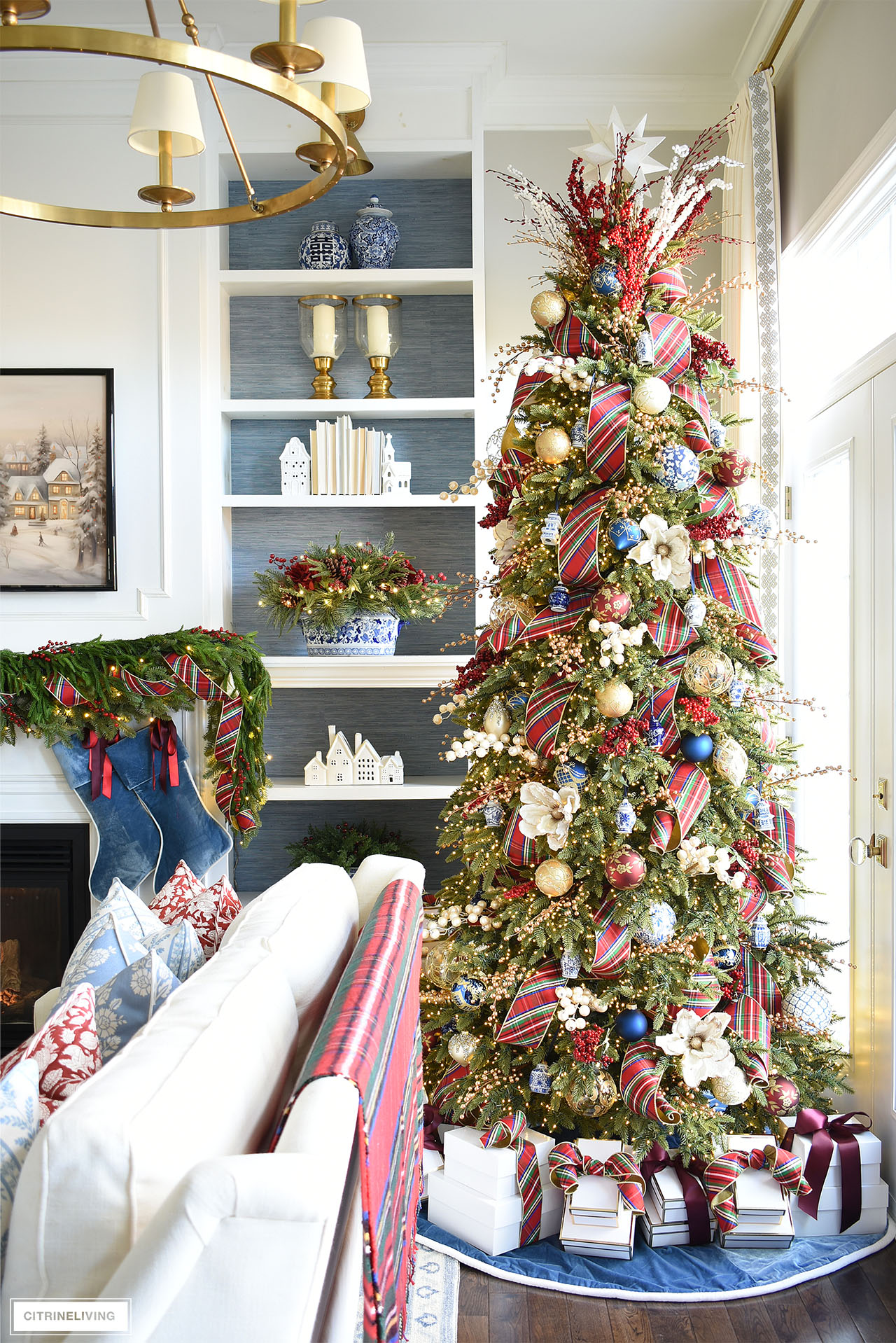 Christmas tree with plaid ribbon, blue and white ornaments, blue velvet tree skirt and stockings.